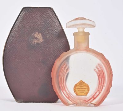 un petit flacon de parfum à côté d'un petit étui
