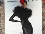 a poster of a woman wearing a black dress and a red hat