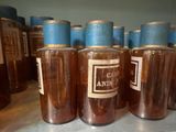 many jars of liquid sitting on a shelf in a room