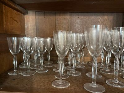 de nombreux verres à vin vides posés sur une étagère en bois