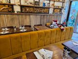 des tables et des chaises dans un restaurant aux murs en bois, avec un canapé jaune