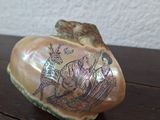 a small shell with a picture on it sitting on a table
