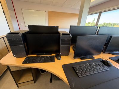 un bureau sur lequel se trouvent plusieurs ordinateurs et un clavier