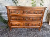 a wooden dresser that is sitting in front of a brick wall