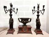 pair of antique bronze figurines on a table with a white brick wall