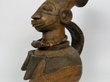 une image représentant une statue en bois d'un homme portant un chapeau sur la tête