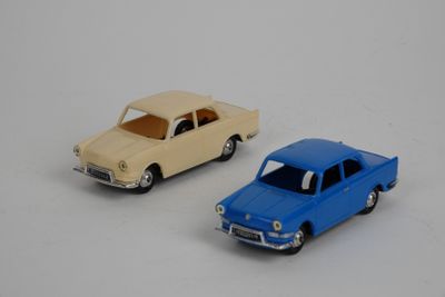 deux voitures jouets assises l'une à côté de l'autre sur une surface blanche