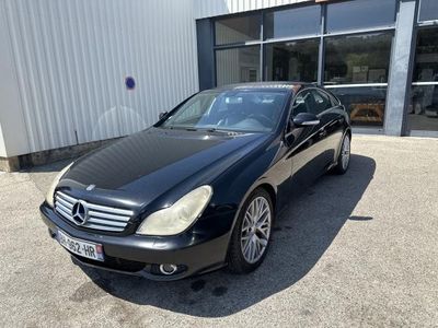 Une Mercedes Classe S noire garée devant un immeuble