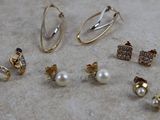 several pairs of earrings and rings are laying on a table