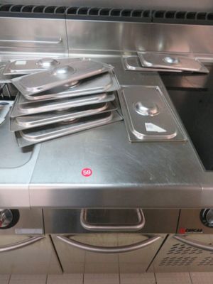 several pans are stacked on top of a stove in a kitchen