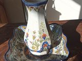 un vase posé sur un plateau, lui-même posé sur une table, avec une lampe en arrière-plan