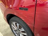 a close up of a red car with a sticker on it