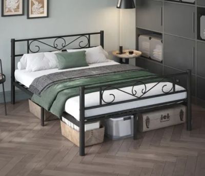 a bed with a metal frame and a green blanket