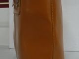 a brown bag with a yellow handle and a book in front of it