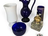 a blue vase, a blue vase, a white vase, and a blue bowl on a white surface