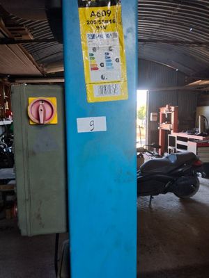 a blue pole with a sign on it in a garage