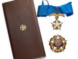 un livre, une médaille et un marque-page posés les uns à côté des autres