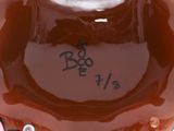 a brown vase with writing on it sitting on a table