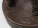 a bronze statue of a person standing on top of a base