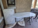 une table et des chaises en marbre sous le porche