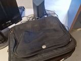 a black bag sitting on top of a desk next to a laptop computer