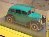 a green toy car in a clear box on a table