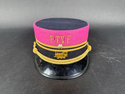pink and black hat with gold trim on top of a black table