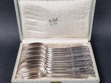 a set of six silverplated serving spoons in a case
