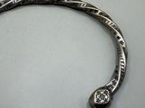 a close up of a silver bracelet with a snake on it