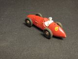 a red toy car that is sitting on a black surface