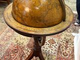 someone is looking at a globe on a stand in a room