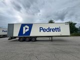 La caravane est garée sur un parking, avec un ciel nuageux en arrière-plan.