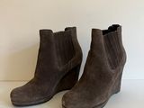 une paire de bottines en daim marron posées sur une surface blanche