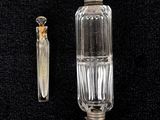 a small glass bottle with a metal cap next to a small glass bottle with a metal cap