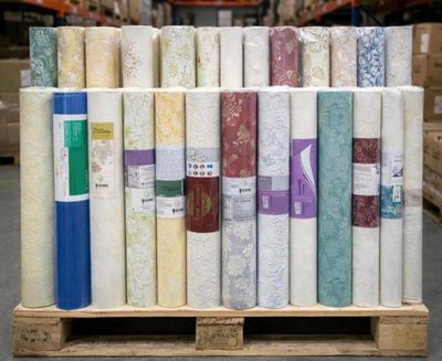 many rolls of fabric on a pallet in a warehouse
