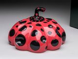 a red and black polka dot pumpkin shaped container