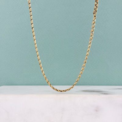 a gold chain necklace on a marble surface