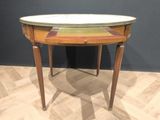 a small table with a marble top on a hard wood floor
