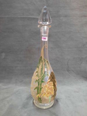 une bouteille en verre décorée, posée sur une table