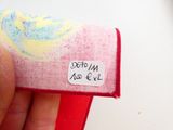 une personne tenant un morceau de tissu sur lequel est collé un autocollant