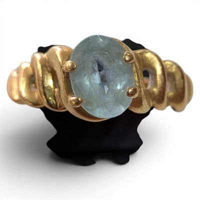 an image of a gold ring with a blue topaz stone