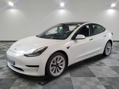 La Tesla Model 3 blanche est garée dans une salle blanche