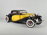 une maquette de voiture jaune et noire posée sur une surface grise