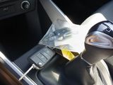 a drink in a plastic cup in the center console of a car