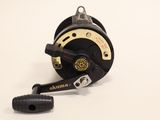 a close up of a fishing reel on a white surface