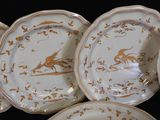 many plates with gold designs on them on a black surface
