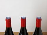 three bottles of wine sitting on a wooden table