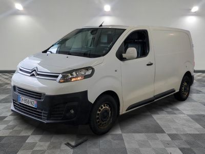la camionnette blanche est garée dans une grande pièce au sol en damier