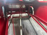 a close up of a red truck with a steering wheel
