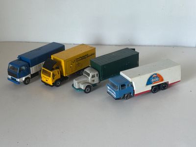 quatre camions miniatures alignés sur une table